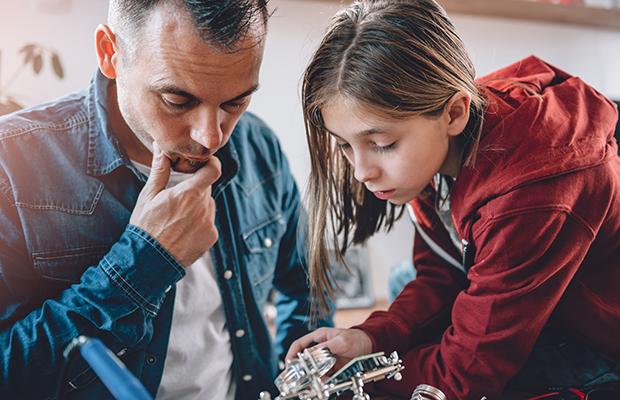 dad and young teen daughter working on a project